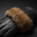 Black leather gloves with fur trim - close-up detail