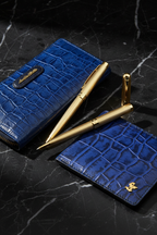 Gold pen and blue croco wallet detail shot