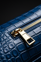 Macro close-up - royal blue croco leather texture and gold zipper