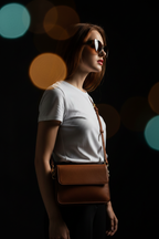 Brown leather crossbody bag - model side profile with sunglasses