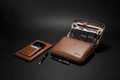 Harbinger Tech Kit open with cables, phone wallet and pen on wooden surface