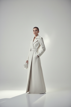 Model wearing women's long white leather coat, cinematic studio shot